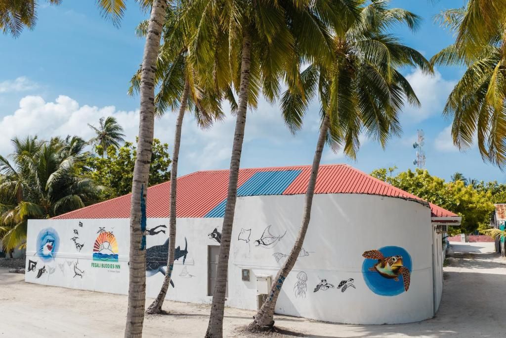 A building with a red roof and a mural of sea creatures on its side.