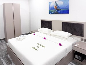 Una habitación de hotel con una cama, una mesita de noche, un armario y un cuadro en la pared.