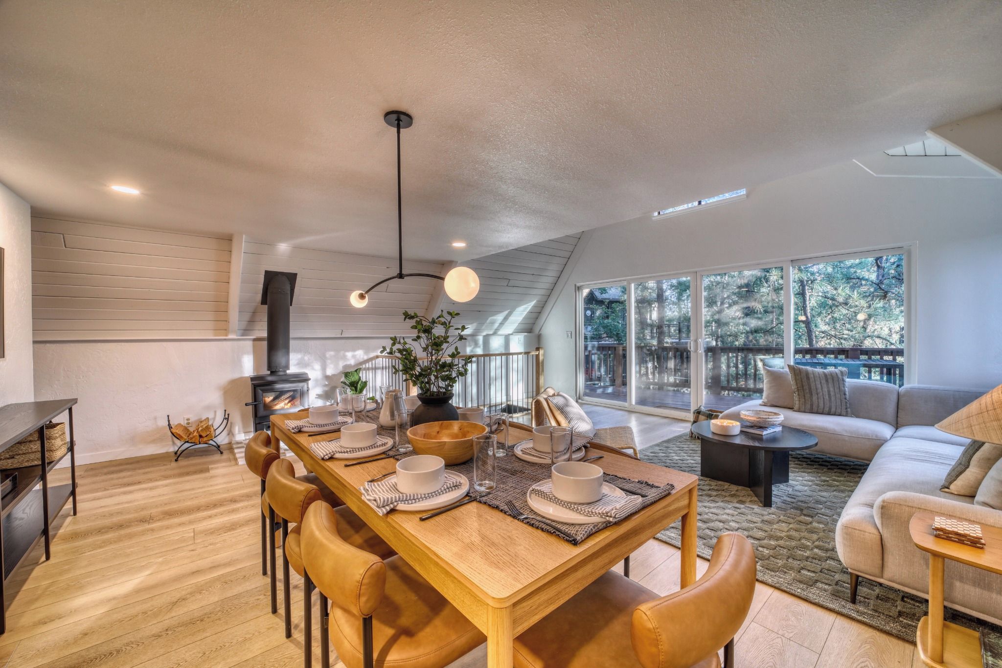 A modern interior with a dining area, a sofa, and a large window.