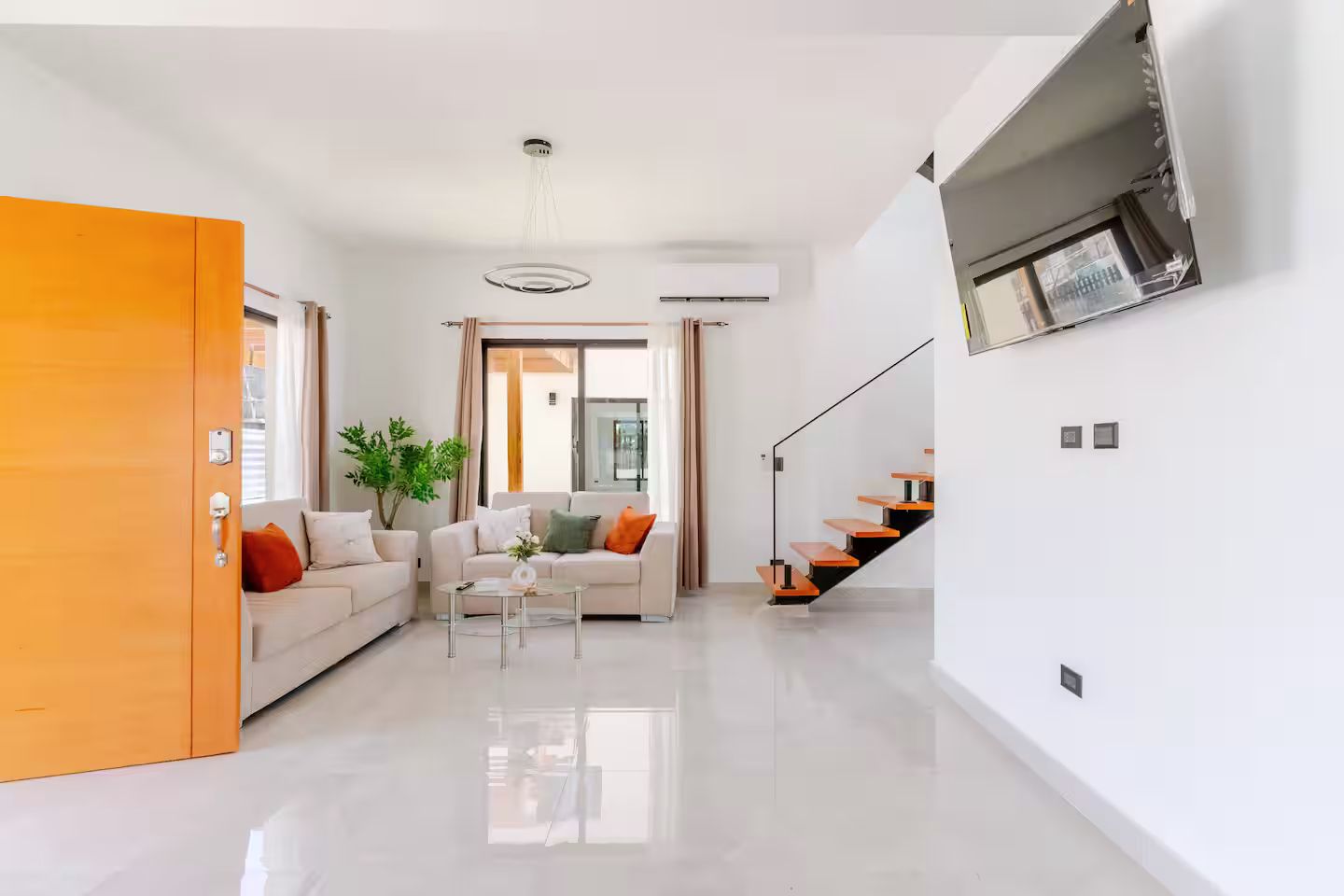 Un salon moderne avec un canapé, une table basse et un escalier.