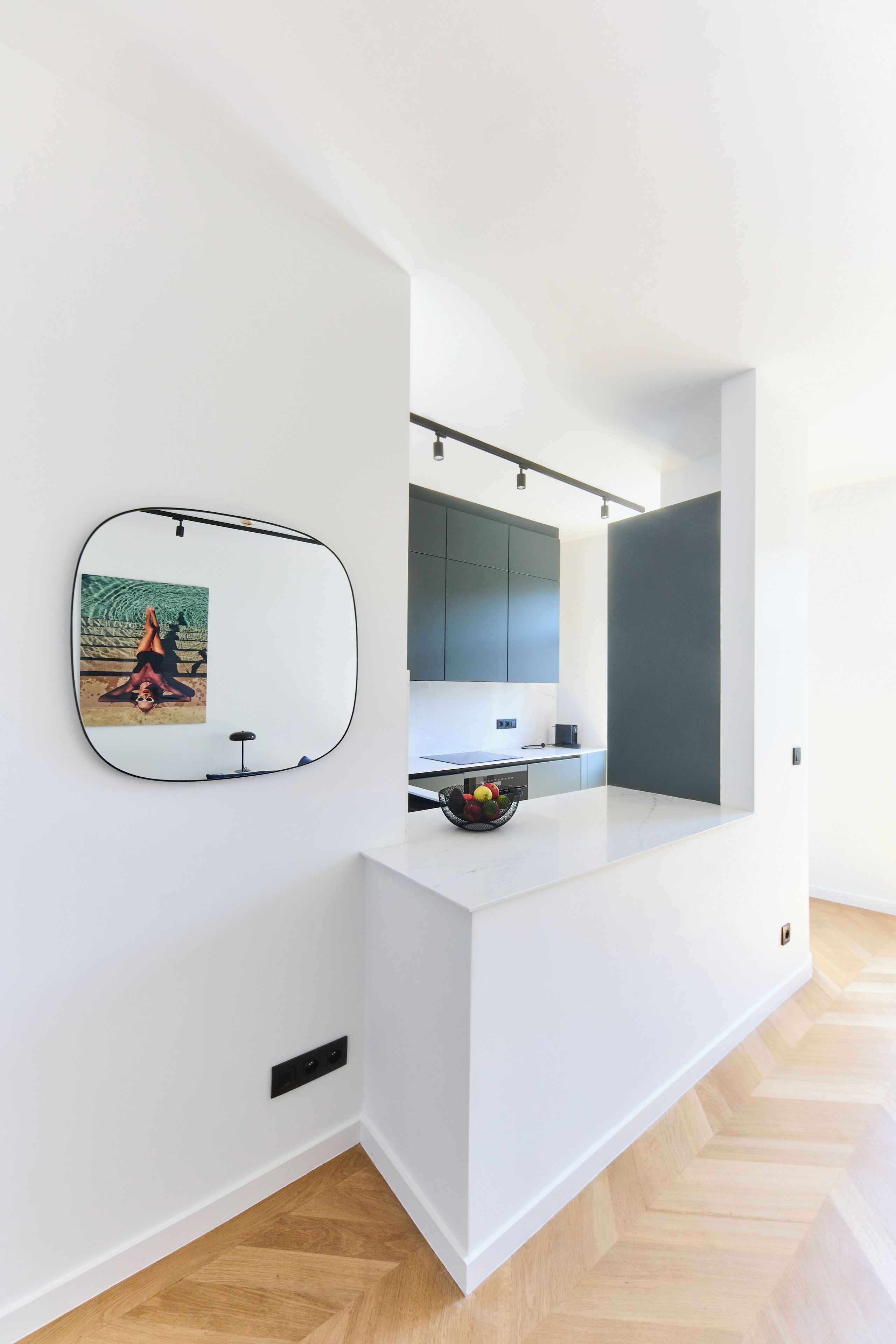 A modern kitchen with a white countertop, a sink, and a dining area.