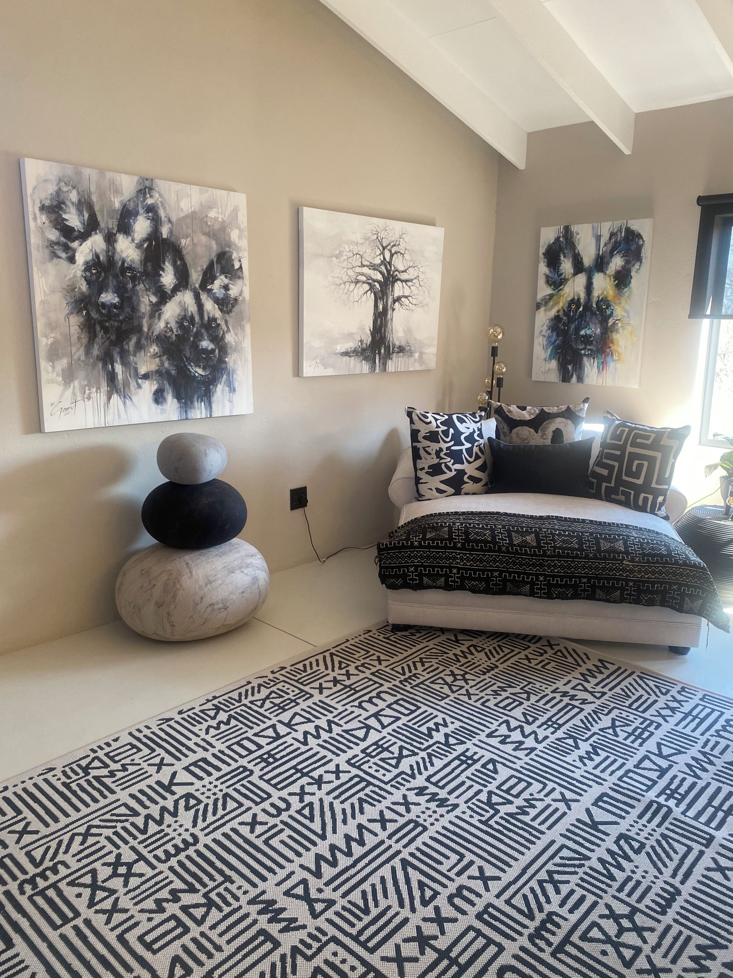Une chambre à coucher avec un lit, un tapis et des œuvres d’art mural.