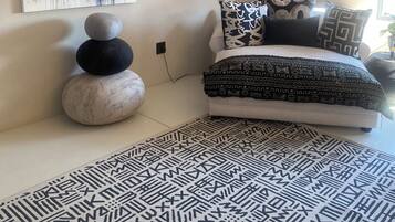 Une chambre à coucher avec un lit, un tapis et des œuvres d’art mural.