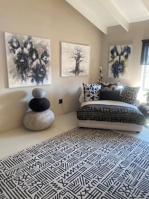 Une chambre à coucher avec un lit, un tapis et des œuvres d’art mural.