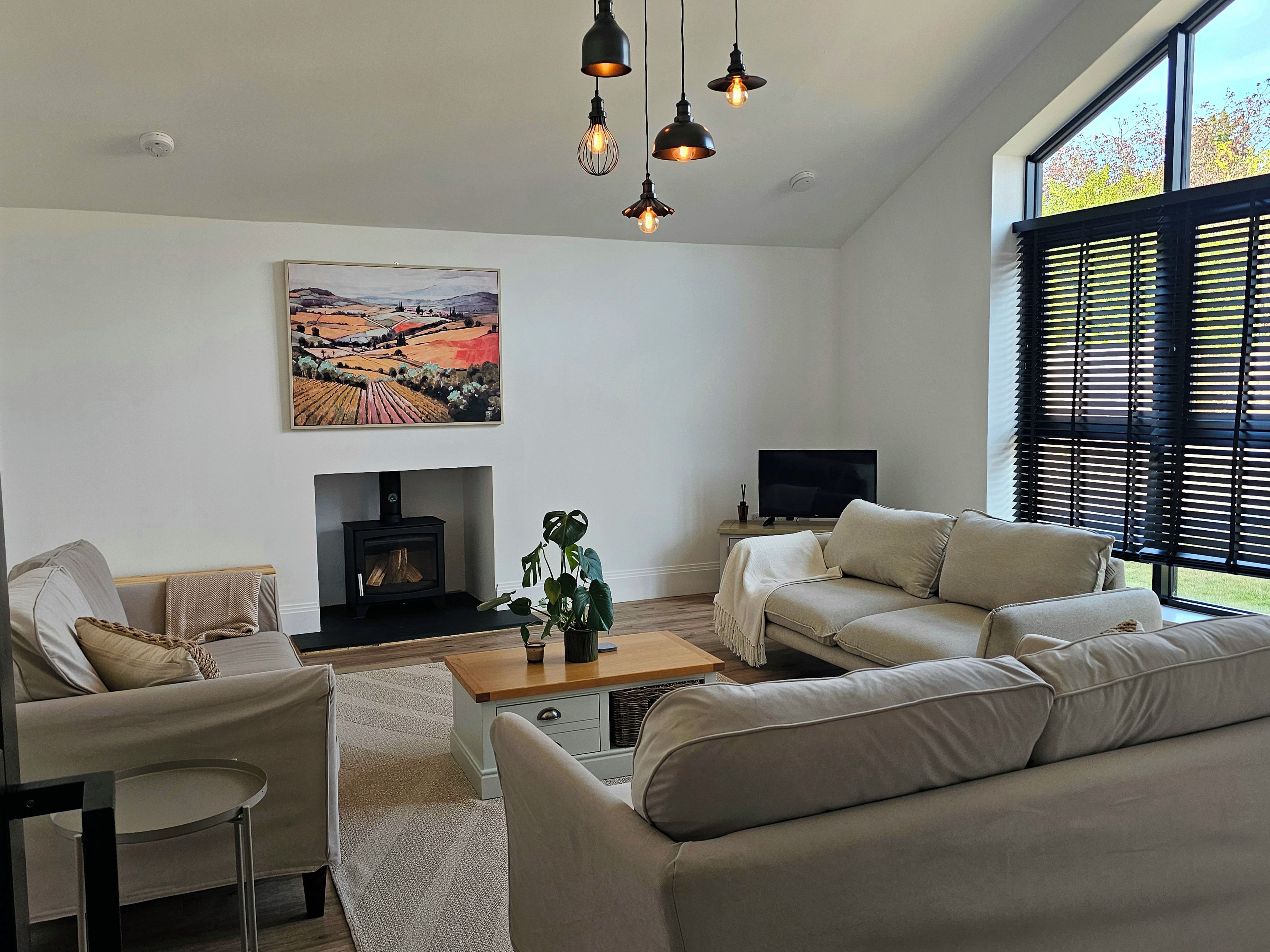 Ein Wohnzimmer mit Kamin, Sofas, einem Couchtisch und einem Fernseher.