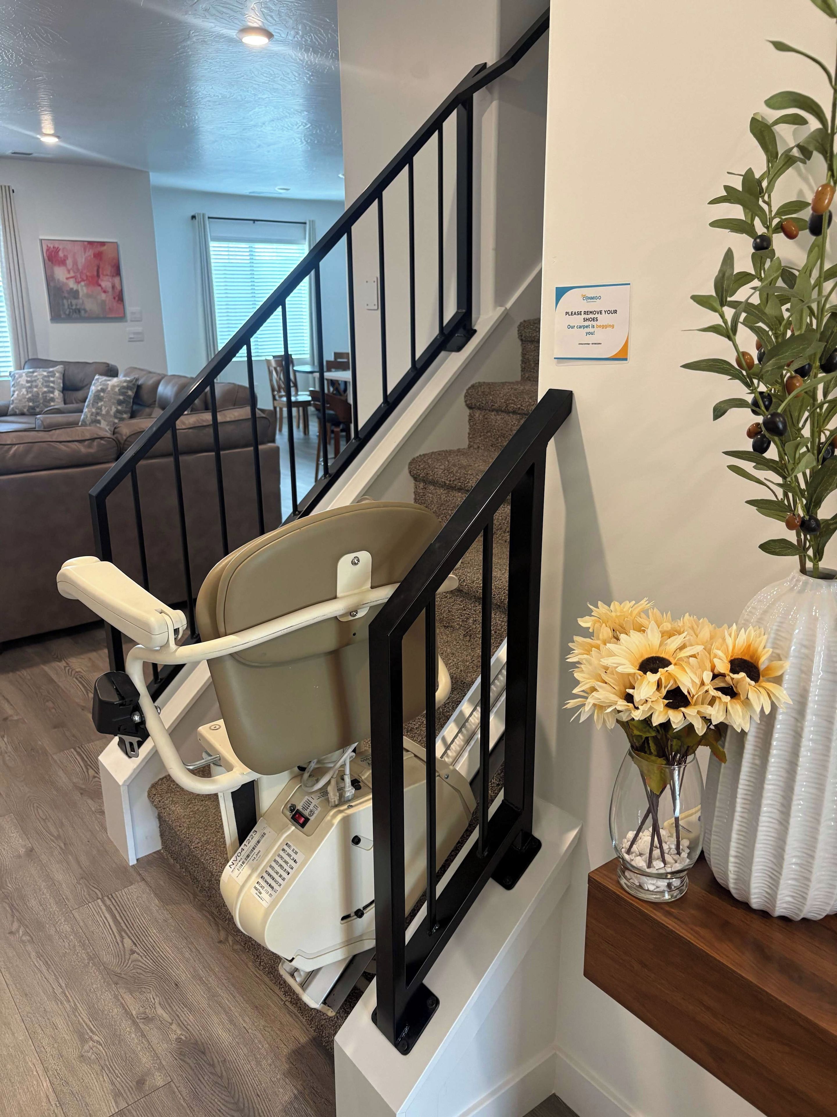 Ein Wohndekor mit Treppe, Trainingsgerät, Blumen in einer Vase und einem Schild an der Wand.