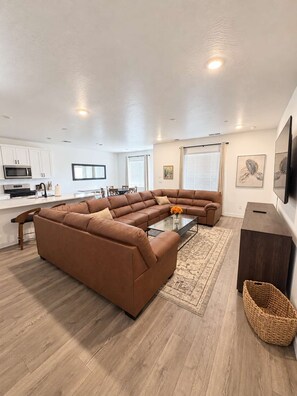 A modern living room with a sectional sofa, a coffee table, and a TV. - Long Valley Family Stay - Sleeps 14 (Washington)
