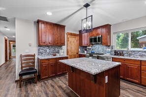 Una cocina moderna con armarios de madera, encimeras de granito y una isla grande.