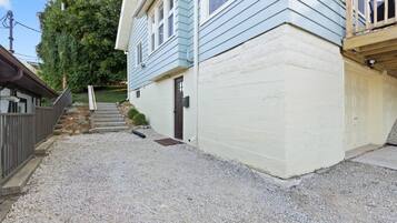 A two-story house with a gravel driveway and a wooden deck.