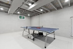 Una mesa de ping pong en una habitación con paredes blancas y suelo de hormigón.