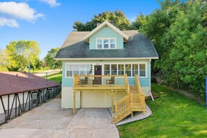 Ein eingeschossiges Haus mit einer Veranda, einer Garage und einer kleinen Terrasse.