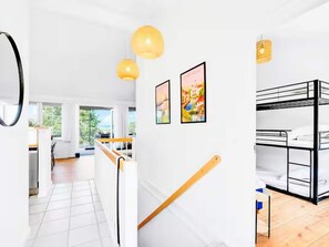 Ein modernes Interieur mit Stockbetten, einer Treppe und Kunstwerken an den Wänden.