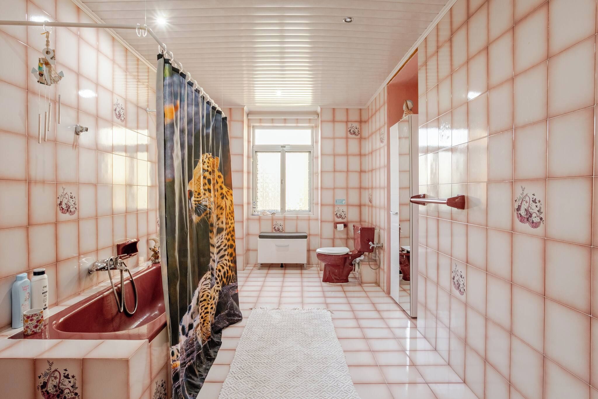 Een badkamer met een bad, toilet en douche.