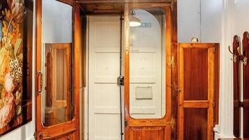 Una habitación con suelo estampado, una puerta blanca y una lámpara colgante.