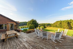 A wooden deck with outdoor furniture and a swimming pool.
