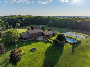 Una casa gran amb una pista de tennis i una piscina.