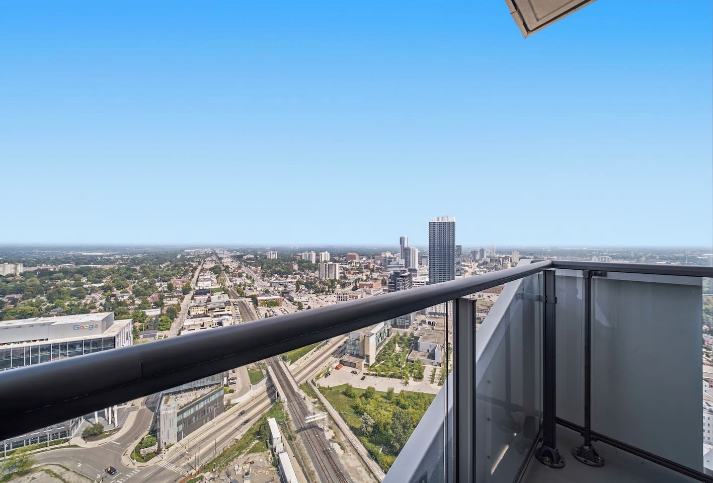 A high-rise building with a clear view of a cityscape, including roads and other buildings.
