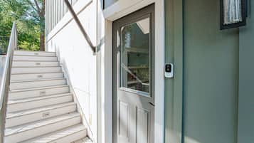A staircase leading to a door with a window, a mailbox, and a wall-mounted light fixture.