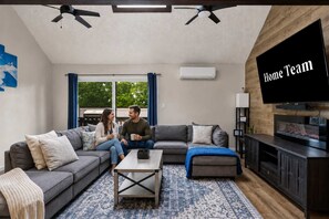 A modern living room with a sectional sofa, a coffee table, and a flat-screen TV. - Camelback Mountain Escape | Sleeps 12 (Tannersville)