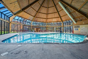 A large indoor swimming pool with a wooden roof and glass walls. - Camelback Mountain Escape | Sleeps 12 (Tannersville)