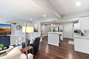 A modern kitchen with white cabinets, a built-in island, and stainless steel appliances. - Shamrock Bungalow Near NoDa + Plaza Midwood (Charlotte)