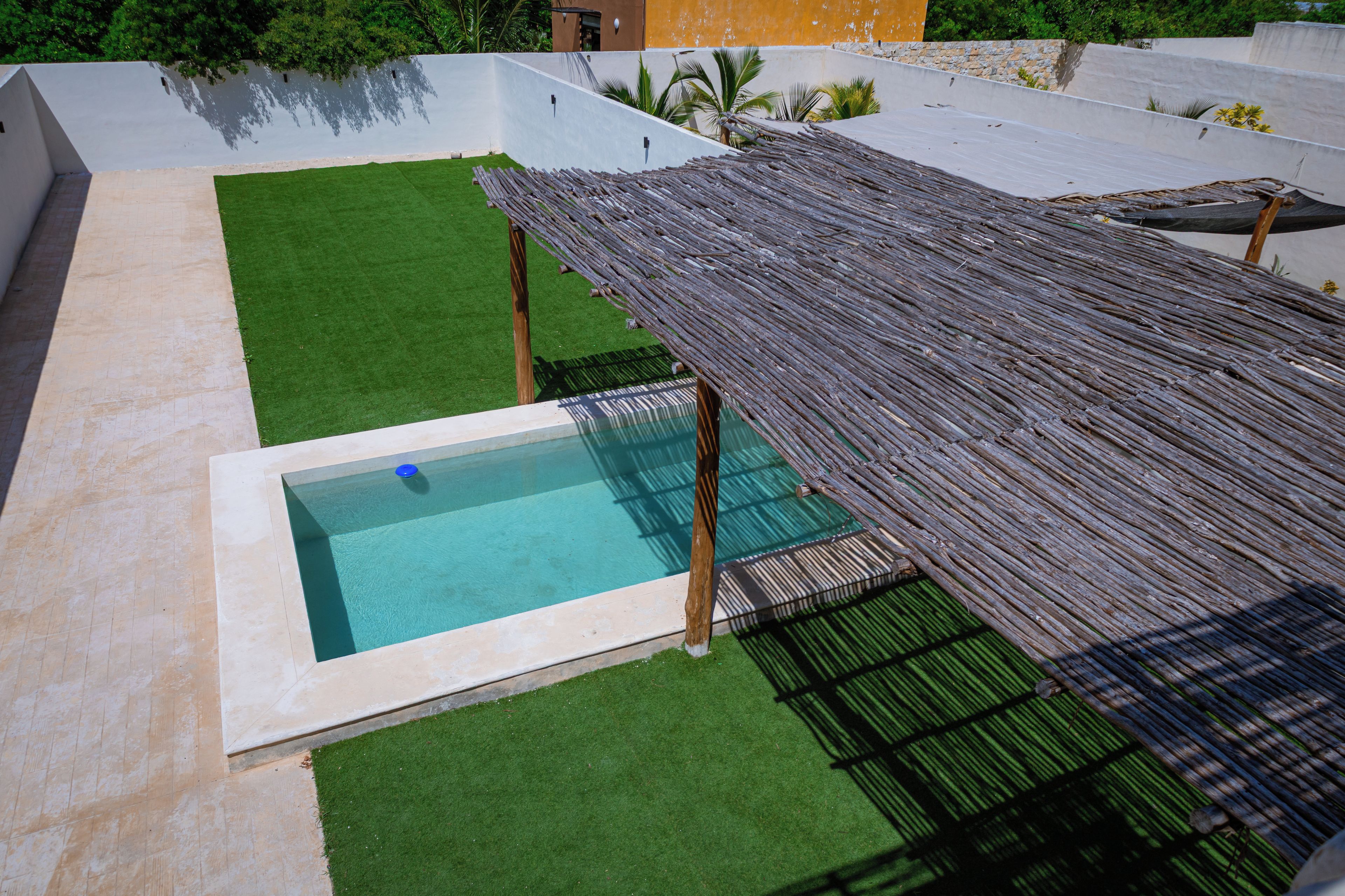 A rooftop pool with a wooden deck and a small pool area.