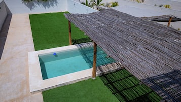 A rooftop pool with a wooden deck and a small pool area.