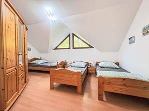 A bedroom with two wooden beds, a wardrobe, and a skylight. - Ferienapartments Adenau by Interhome (Adenau)