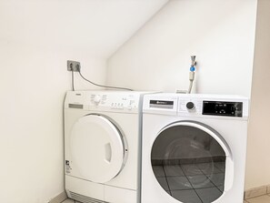 A front-loading washing machine and dryer side by side in a laundry room. - Ferienapartments Adenau by Interhome (Adenau)