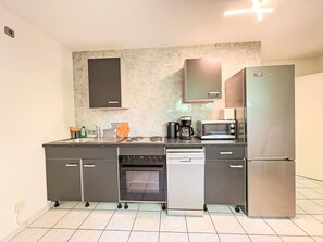 A compact kitchen with a built-in oven, microwave, and refrigerator.