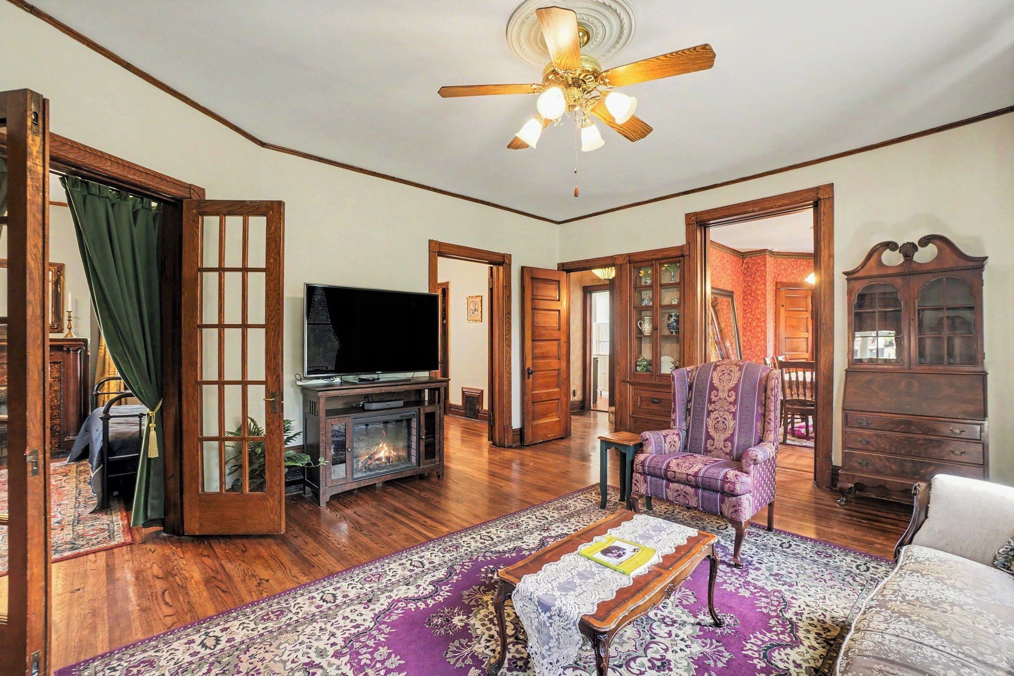 A traditional living room with a fireplace, television, and a large window.