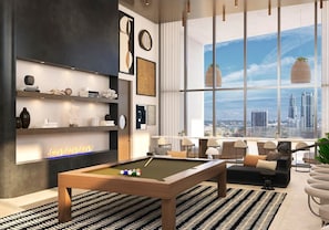 A modern living room with a pool table, a fireplace, and a large window with a city view. - Elite Studio City Escape (Miami)