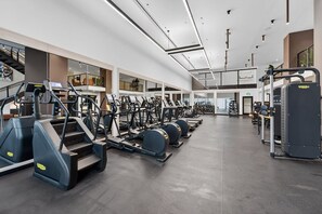 Ein modernes Fitnessstudio mit verschiedenen Cardiogeräten, Gewichten und einer großzügigen Gestaltung.