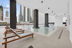 A rooftop swimming pool with lounge chairs and a view of surrounding high-rise buildings. - Downtown Miami Luxe 1BR! (Miami)