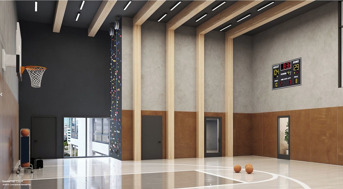 A basketball court with a scoreboard, a basketball hoop, and a digital clock.