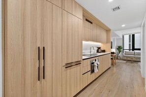 A modern kitchen with wooden cabinets, a countertop, and a built-in oven. - Modern Luxe Downtown Stay (Miami)