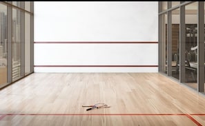 A room with a wooden floor, a pair of tennis rackets, and a red line marking the boundary. - Urban Luxury Studio Miami (Miami)