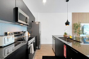 A modern kitchen with stainless steel appliances, a microwave, and a built-in oven. - Magical Family Getaway (Kissimmee)