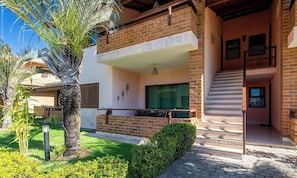 A two-story building with a balcony, a staircase, and a well-maintained garden. - Ground Floor Apt. w/ Balcony & Pool Bvd0003 (Porto Seguro)