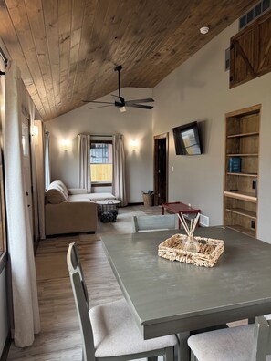A modern living room with a sofa, dining table, and a ceiling fan. - Bitty Box ~ A charming, comfortable and surprisingly spacious home in Toledo (Toledo)