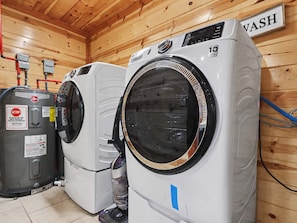 A laundry area with two front-loading washing machines and a water heater. - Smoky Mtn Views | Indoor Pool, Hot Tub & Sauna (Sevierville)