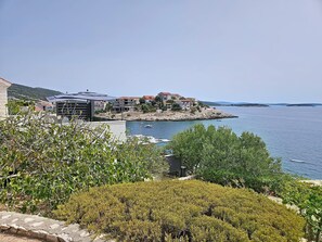 Ein Küstenwohngebiet mit modernen Gebäuden, einem Yachthafen und freiem Blick auf das Meer.