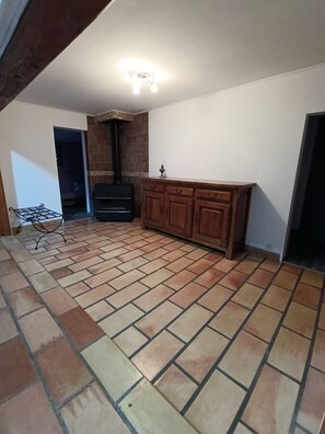 A room with a tiled floor, wooden cabinets, a fireplace, and a ceiling light fixture. - Maison de Campagne 9 places (Lançon-Provence)