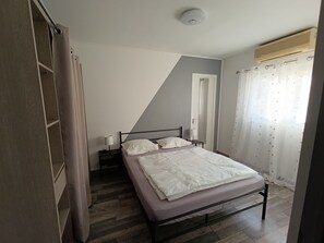 A bedroom with a bed, bedside tables, a wardrobe, and a ceiling light. - Maison de Campagne 9 places (Lançon-Provence)