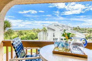 Ein Balkon mit Blick auf ein modernes Haus und das Meer.
