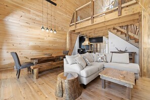 A wooden interior with a sofa, bench, dining table, and a staircase. - Spa & Nature | Celestra (Grenville-sur-la-Rouge)