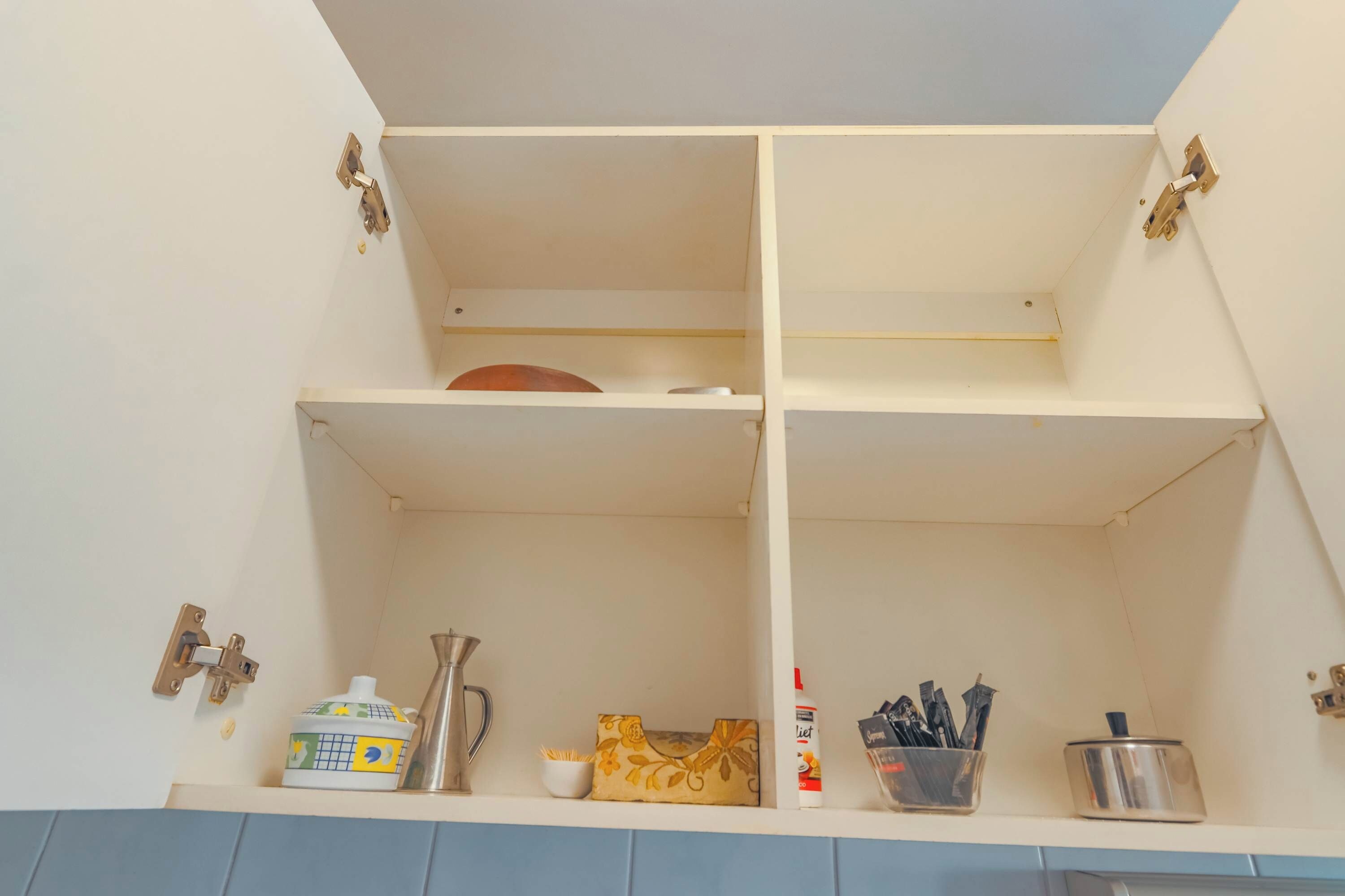 Un meuble de cuisine avec trois étagères, un porte-épices et une canette de soda allégé.