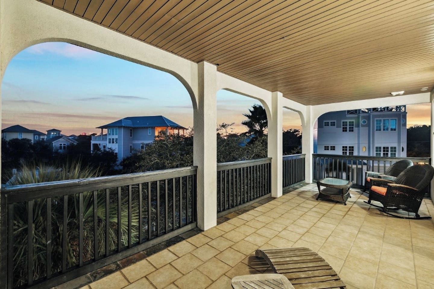 A covered outdoor patio with a view of houses in the background.