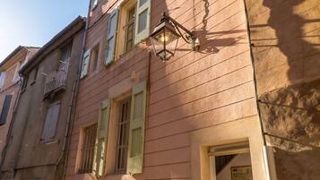 A multi-story building with a traditional facade, a visible staircase, and a small entrance with a door.