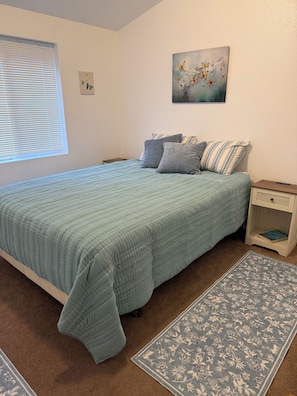 A bedroom with a bed, pillows, a nightstand, a painting, a window with blinds, and a rug. - Beautiful Mountain Views! 3 Bed / 2 Bath house overlooking Pebble Creek Ski Hill (Inkom)